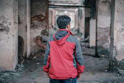 Rear view of man standing by building