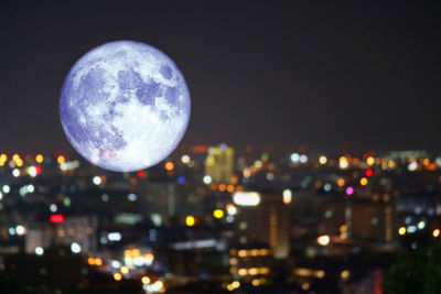 Close-up of illuminated cityscape against sky at night