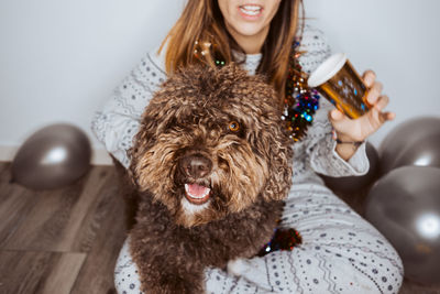 Portrait of dog with woman sitting on floor at home