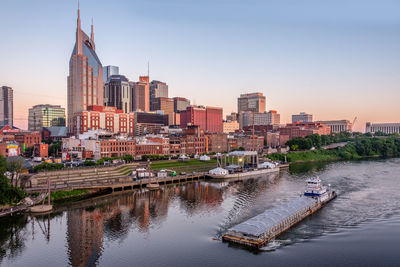 River amidst buildings in city against clear sky