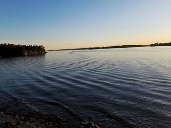 Scenic view of lake against clear sky during sunset