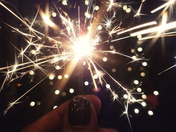 Close-up of hand holding sparkler at night