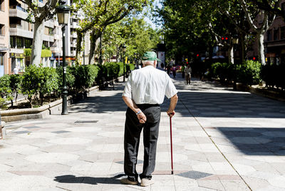 Rear view of woman walking on footpath