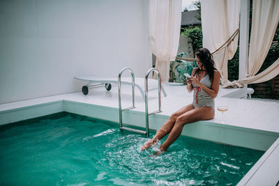 Woman jumping in swimming pool