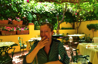 Portrait of smiling woman sitting at restaurant table