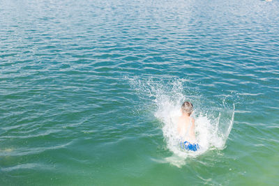 High angle view of boy swimming in sea