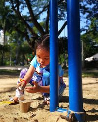 Cute girl playing with sand at park