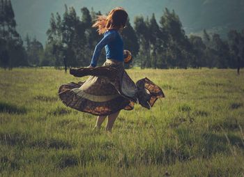 Woman dancing on grassy field