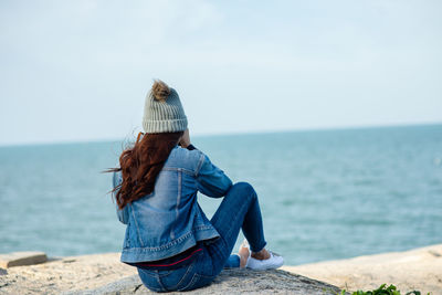 Rear view of woman looking at sea against sky