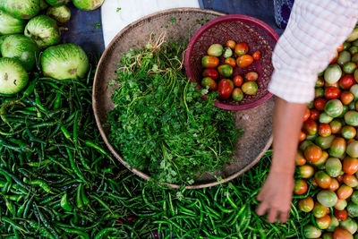 Cropped image of hand choosing vegetables at market stall