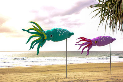 Close-up of animal representation on beach against sky