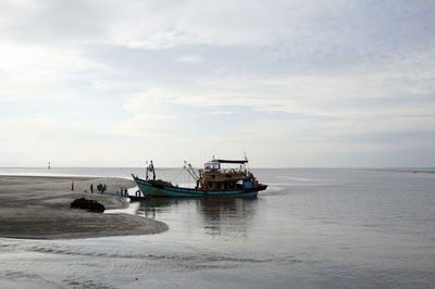 Ship moored on sea against sky