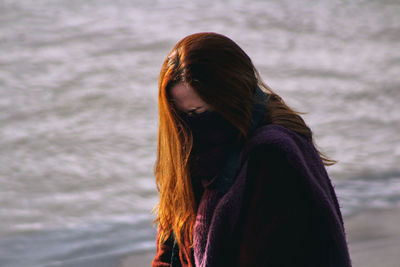 Close-up of woman with hair standing in ocean background