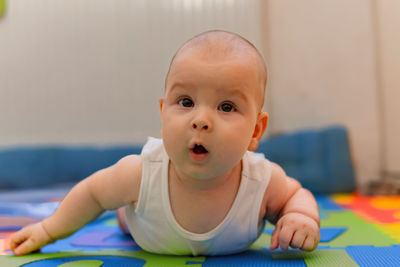 Close-up of cute baby boy at home, trying to craw