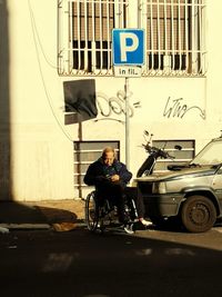 Man sitting on road in city