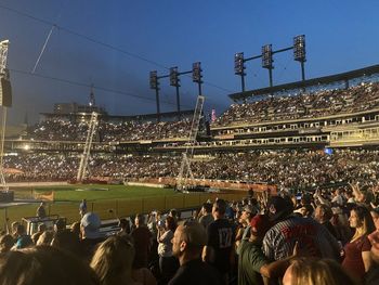 Group of people looking at stadium against sky