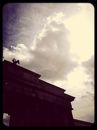 Low angle view of building against cloudy sky