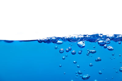 Close-up of water drops on glass against white background