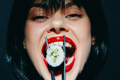 Close-up portrait of young woman eating food