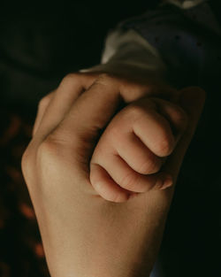 Close-up of mother holding hands 