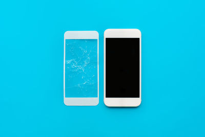 Close-up of smart phone over blue background