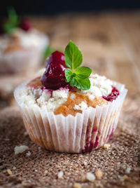 Close-up of cherry muffin with crumbly topping on wooden background