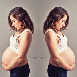 Beautiful young woman standing against white background