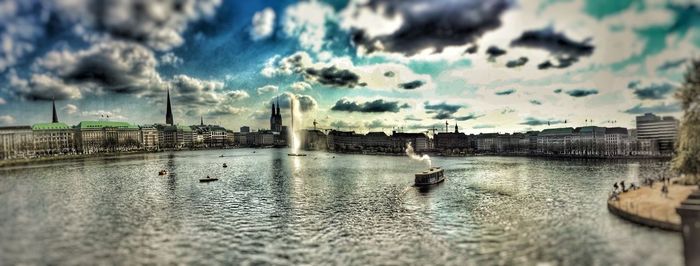 River in city against cloudy sky