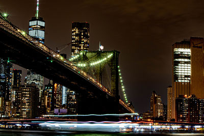 Illuminated modern buildings in city against sky at night