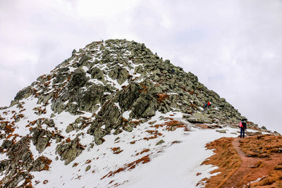 Low angle view of snow covered mountain against sky