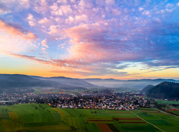 Aerial view of town against sky during sunset