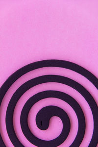 Close-up of pink spiral over white background