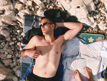 Portrait of man sunbathing on beach