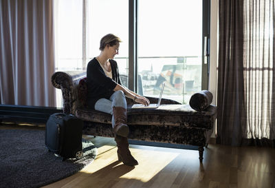 Businesswoman using laptop in hotel room