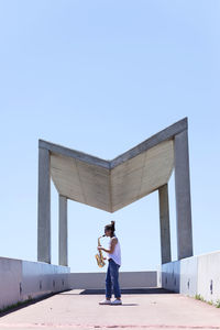 Full length of man standing against clear blue sky