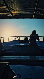 Man sitting on boat against sky