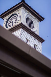 Low angle view of clock tower against blue sky