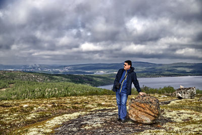 Full length of young man standing on rock