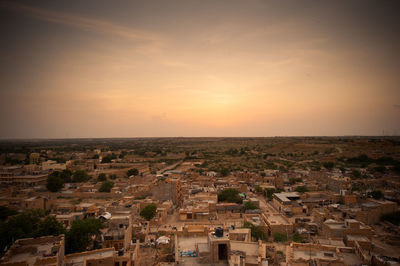 Aerial view of townscape against sky at sunset