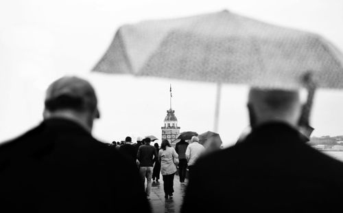 Rear view of people walking in front of building
