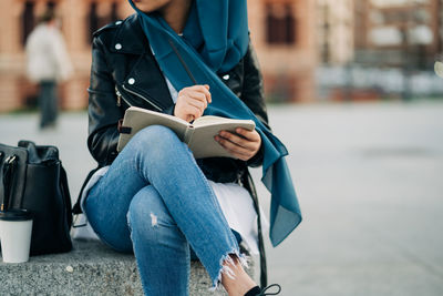 Midsection of woman reading book