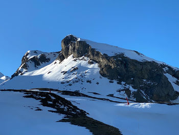 Scenic view of snowcapped mountains against clear blue sky