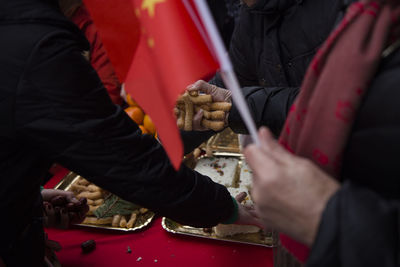 Midsection of people having food in market