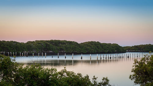 Scenic view of lake against clear sky during sunset