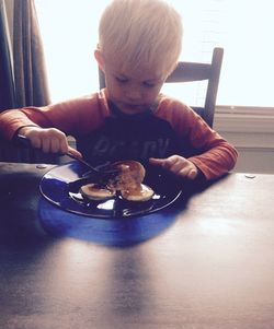 Boy playing in plate on table