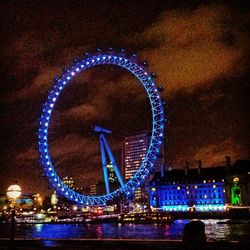 Illuminated ferris wheel at night