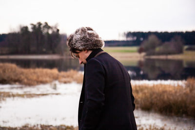 Side view of young man standing on field