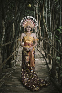 Statue of woman standing on tree trunk