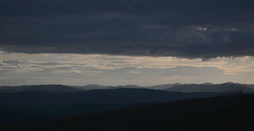 Scenic view of silhouette mountains against sky at sunset