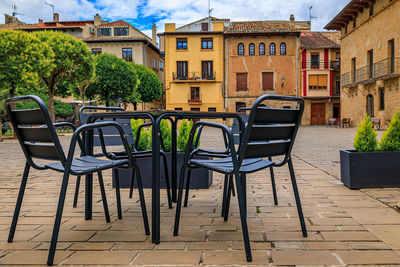 Empty chairs and tables at outdoor cafe